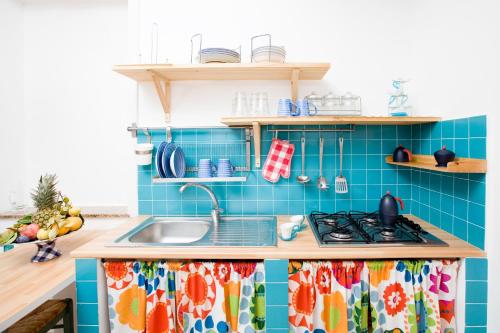 a kitchen with blue tiles and a sink at Il Vicolo B&B in Milazzo