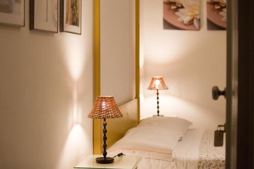 a bedroom with two lamps on a bed at Il Vicolo B&B in Milazzo