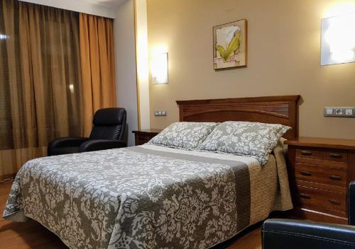 a bedroom with a bed and two chairs at Hotel Reina Isabel in Medina del Campo