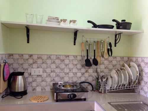 a kitchen counter with a stove and plates and utensils at The Three Shooting Stars in Panglao