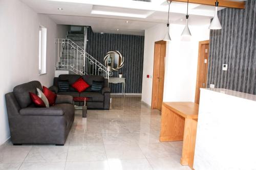 a living room with two couches and a staircase at Fisherman's Cove Guesthouse in Marsaxlokk