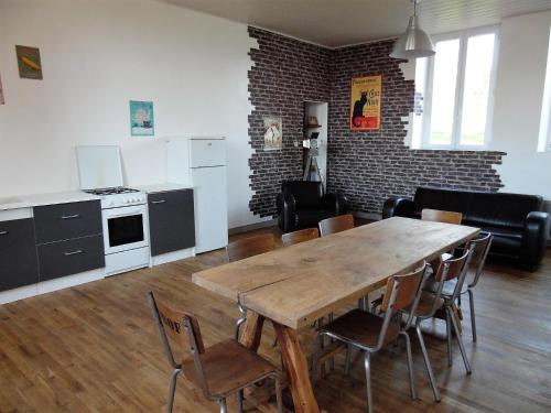 cocina y comedor con mesa de madera y sillas en L'école buissonnière, en Combrand