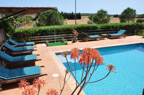 una piscina con sillas azules, una mesa y una planta en Agroturismo Finca Sant Blai, en Campos