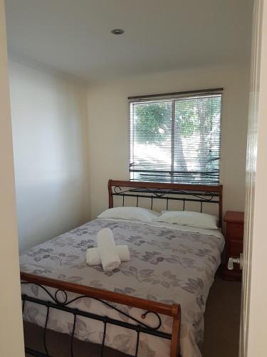 a bedroom with a bed with two towels on it at Koonwarra Holiday Park in Lakes Entrance