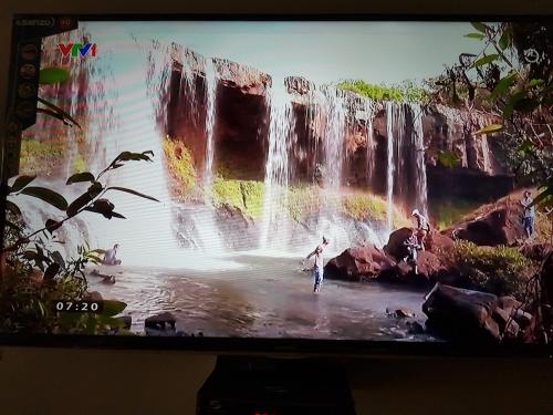 a television screen with a painting of a waterfall at Bac Huong Hotel in Kon Tum