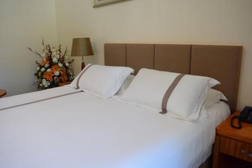 a bedroom with a large bed with two white pillows at Saipan Beach Hotel in Saipan