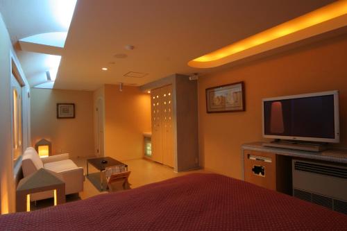 a bedroom with a bed with a television and a living room at Hotel Chateau Briant (Adult only) in Saitama