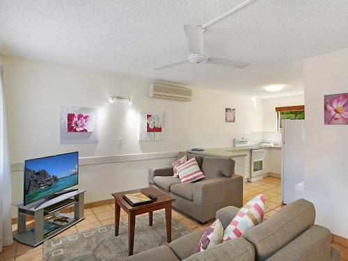 sala de estar con sofá y TV en Cayman Quays en Noosaville