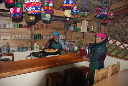two women standing at a bar in a restaurant at Turismo Comunitario La Esperanza in Colta