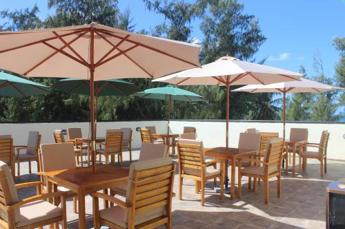 a group of tables and chairs with umbrellas at Saipan Beach Hotel in Saipan