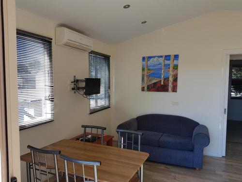 a living room with a couch and a table at Koonwarra Holiday Park in Lakes Entrance