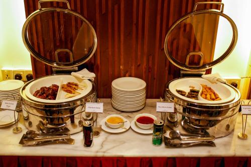 a buffet with plates of food on a table at The Grandmark Dhaka in Dhaka