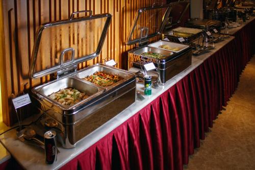 a buffet line with dishes of food in sinks at The Grandmark Dhaka in Dhaka