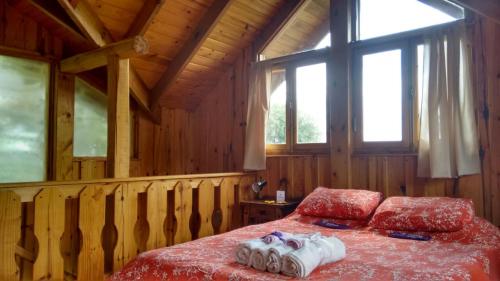 1 dormitorio con 1 cama en una cabaña de madera en La Secreta en Villa Giardino