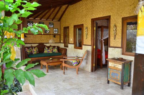 - un salon avec un canapé et une table dans l'établissement Guci Guesthouses, à Ubud