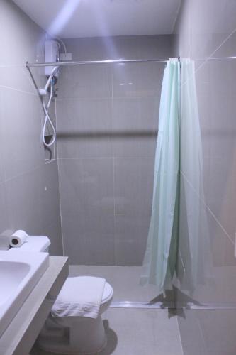 a bathroom with a shower and a toilet and a sink at Butuan Grand Palace Hotel Annex in Butuan