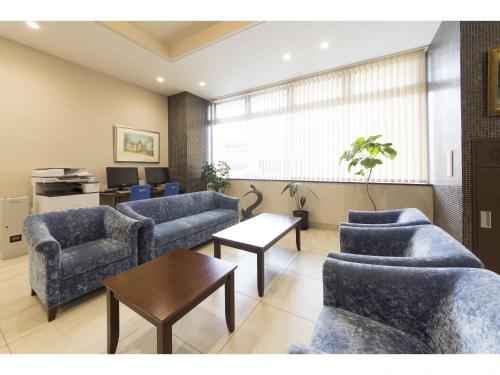 a waiting room with blue couches and a table at Hotel Super Tomari in Fujieda