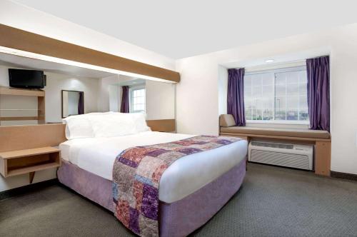 a hotel room with a large bed and a window at Microtel Inn & Suites by Wyndham Mankato in Mankato