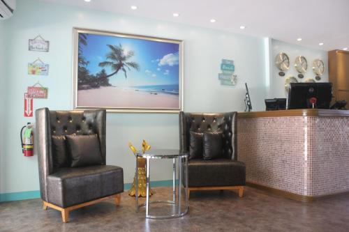 a barber shop with two chairs and a picture of a beach at Saipan Beach Hotel in Saipan