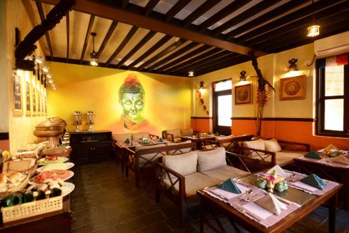 a restaurant with tables and a painting of a woman at Kasthamandap Boutique Hotel in Kathmandu