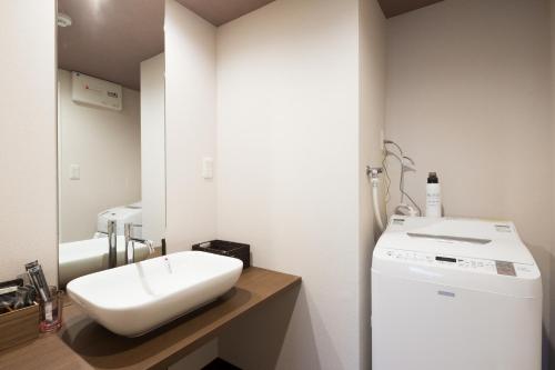 a bathroom with a sink and a washing machine at Kyoto Riverview House Kyoraku in Kyoto