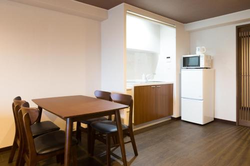 a kitchen with a table and chairs and a refrigerator at Kyoto Riverview House Kyoraku in Kyoto