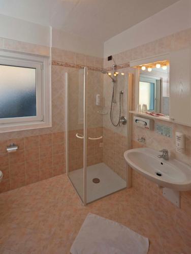 a bathroom with a shower and a sink at Hotel Ladina in Campitello di Fassa