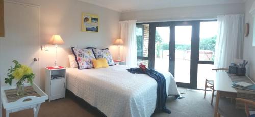 a bedroom with a bed and a balcony at Applecross Sanctuary in Cambridge
