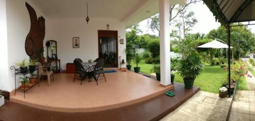a patio with chairs and a table in a house at Samanala Garden Holiday Home in Hikkaduwa