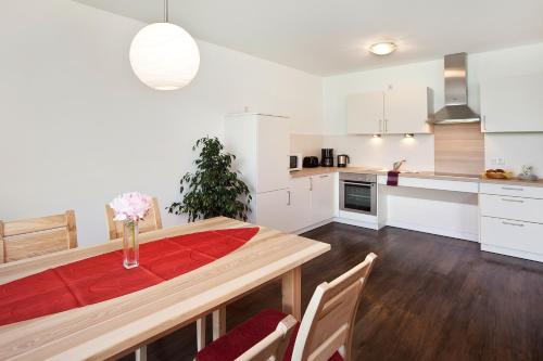a kitchen and dining room with a table and chairs at Seehotel und Appartements Schnöller in Rieden am Forggensee