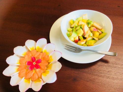 a bowl of salad and a flower on a table at Coza Ceylon in Mount Lavinia