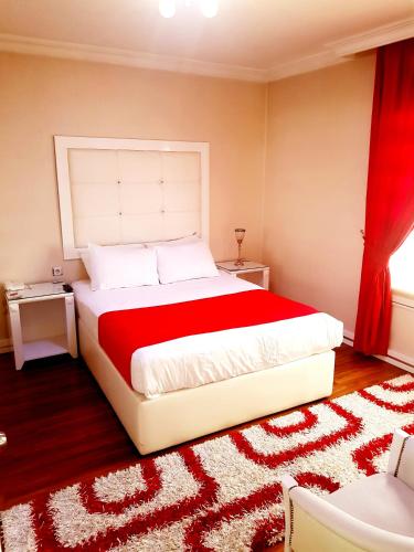 a bedroom with a large bed with a red blanket at Business Park Hotel in Ankara