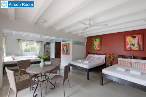 a living room with a table and chairs and a couch at The Duyan House at Sinagtala Resort in Orani