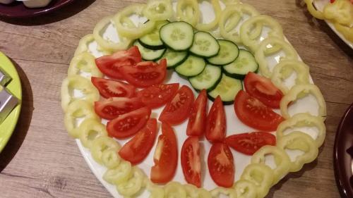 a pizza with tomatoes and cucumbers on a table at Partium Hotel Szeged in Szeged