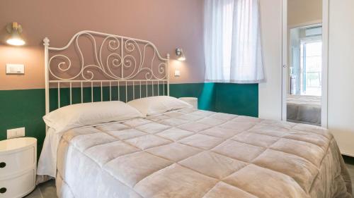 a bedroom with a large bed and a green wall at Fiori sull'Acqua Apartments in Peschiera del Garda