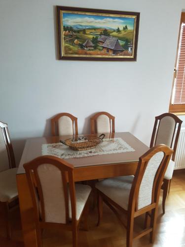 a dining room table with chairs and a picture on the wall at Apartment Joksimovic in Zlatibor
