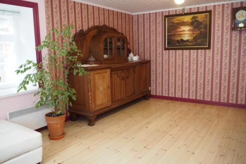 a living room with a wooden cabinet and a plant at Lootuse Apartment in Tallinn