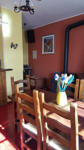 a dining room with a wooden table with a vase of flowers at Allevamento B&B in Pozzolgroppo