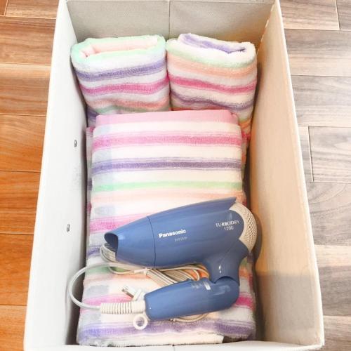 a box with a hairdryer and towels in it at Guest House Fukuoka W301 in Kasugabaru