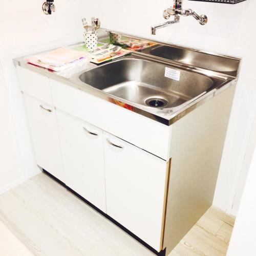 a white kitchen with a sink and a counter at Guest House Fukuoka W302 in Kasugabaru