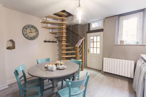 une salle à manger avec une table, des chaises et une horloge dans l'établissement Hissla Riquewihr, à Riquewihr