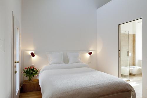 a white bedroom with a large bed and a mirror at Parco Sempione in Milan