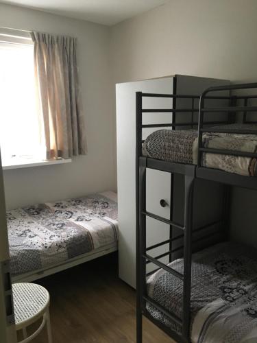 a room with two bunk beds and a window at Appartement Ut & Thus, Resort Amelander Kaap in Hollum