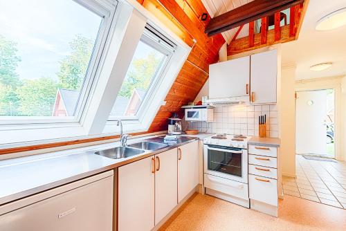 a kitchen with white cabinets and a window at Mötesplats Borstahusen in Landskrona
