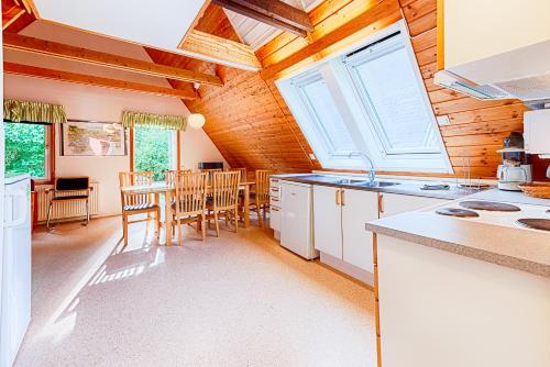 a kitchen with white cabinets and a table with chairs at Mötesplats Borstahusen in Landskrona