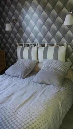 - un lit avec deux oreillers et une tête de lit dans l'établissement villa provençal avec piscine a vias de 10 personnes, à Vias