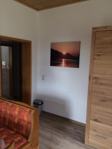 a living room with a couch and a painting on the wall at Pension Hönel-Hof Bad Schandau in Bad Schandau
