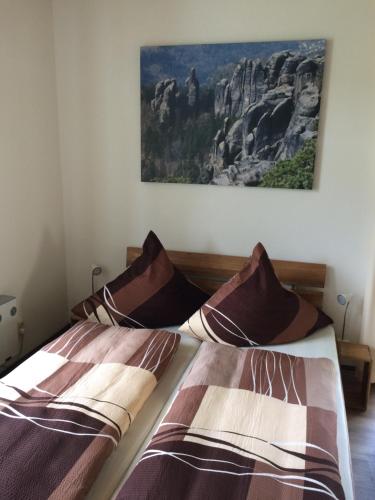 two beds in a bedroom with a picture on the wall at Pension Hönel-Hof Bad Schandau in Bad Schandau