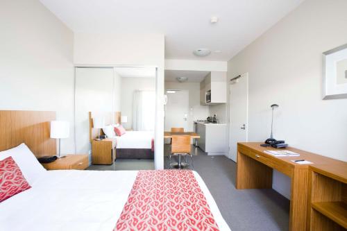 una camera con letto e scrivania e una camera di Gladstone Downtown Central Apartment Hotel Official a Gladstone