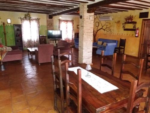 a dining room and living room with a table and chairs at Casa Rural las Médicas in Buendía